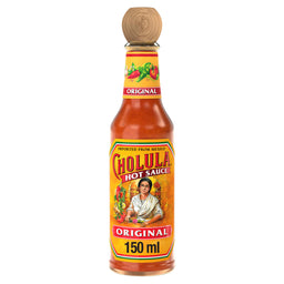 A glass bottle of Cholula Original Mexican Hot Sauce 150Ml is displayed, featuring its distinctive wooden cap and yellow label with an illustration of a woman and peppers.