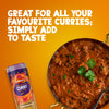 A jar of Schwartz Medium Curry Powder 90G is displayed next to a large pan of rich chicken curry garnished with fresh cilantro and black sesame seeds against a textured orange background.
