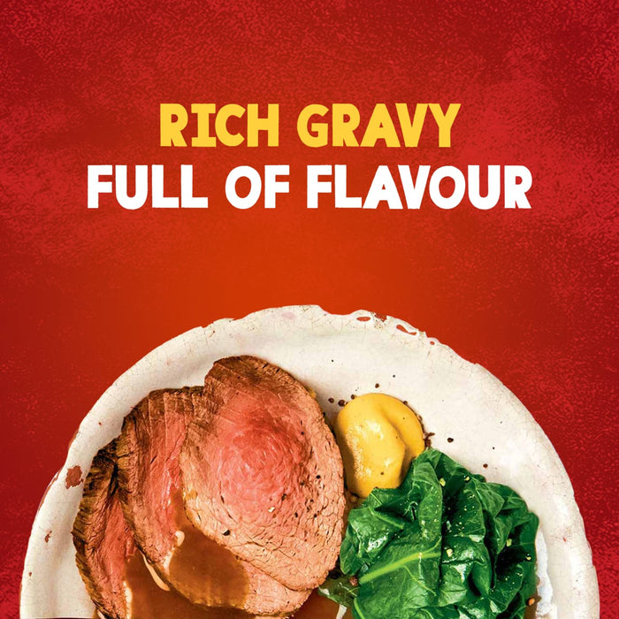 A delicious plate of roast beef with greens and mustard is generously topped with a rich, flavorful sauce made from Schwartz Roast Beef Gravy Mix 27G.