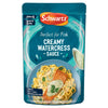A teal microwaveable pouch of Schwartz Creamy Watercress Sauce For Fish 300G featuring a serving suggestion of salmon and pasta drizzled with the green sauce.