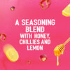 A vibrant pink graphic featuring floating ingredients like lemon slices, red chillies, and a honey dipper to describe the seasoning blend of Schwartz Las Iguanas Honey Chilli Chicken 35G.