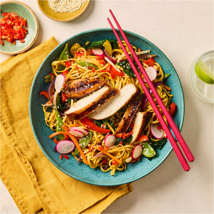 A vibrant bowl of stir fried noodles topped with sliced grilled chicken and fresh vegetables is perfectly seasoned with Schwartz Chinese 5 Spice Seasoning 58G.