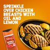 A bottle of Schwartz Smoked Paprika 40G is shown next to a black dish of grilled chicken breasts and lemon wedges on an orange background.
