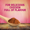 A wooden spoon holds a mound of Schwartz Paprika & Onion Chicken Seasoning 50G over a rustic wooden table against a pink textured background with text for delicious chicken full of flavour.