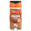 A clear glass jar of Schwartz Ground Cinnamon 39G is shown against a white background, featuring an orange and black cap and a label with an image of cinnamon sticks.