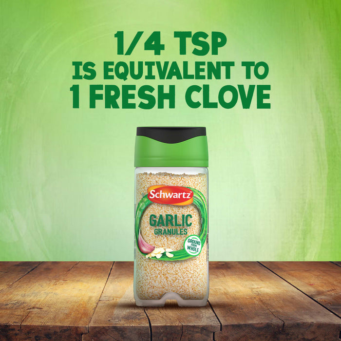 A bottle of Schwartz Garlic Granules 50G sits on a wooden table, with text above explaining that 1/4 teaspoon is equivalent to 1 fresh clove.