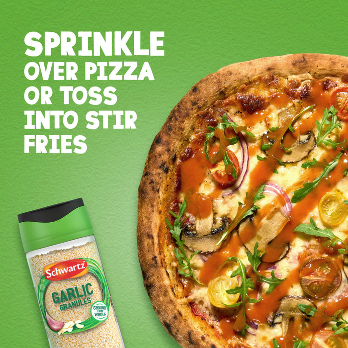 A jar of Schwartz Garlic Granules 50G is displayed next to a freshly made pizza, suggesting it can be sprinkled over pizza or used in stir-fries.