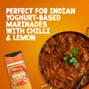 A jar of Schwartz Turmeric Ground 37G is positioned next to a bowl of Indian curry to illustrate its use in yoghurt-based marinades with chilli and lemon.