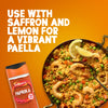 This advertisement image features a jar of Schwartz Paprika 40G next to a pan of vibrant shrimp paella, illustrating the suggestion to use it with saffron and lemon.