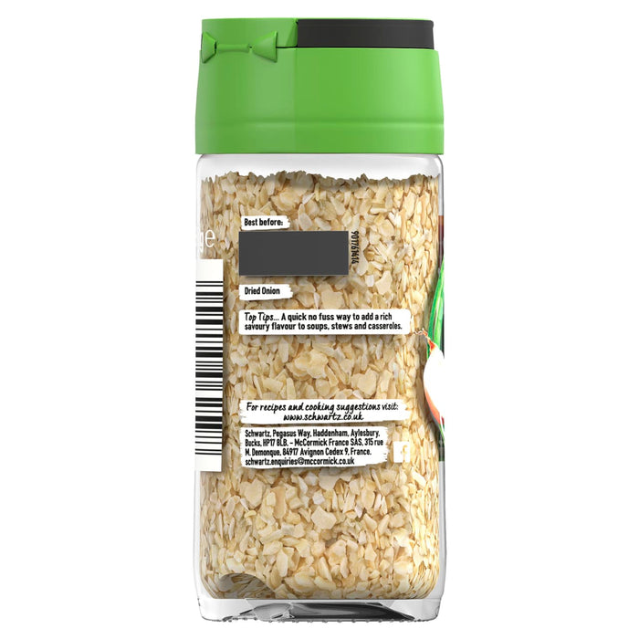 The back of a clear glass jar of Schwartz Dried Onion, showing the product information, usage tips, and company details through the glass.