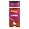 A clear glass jar of Schwartz Harissa 48G spice blend featuring a vibrant purple label with illustrations of red chili peppers and garlic.