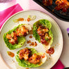 A plate of roasted cauliflower lettuce wraps seasoned with Schwartz Af Sy Korean Seas and garnished with sesame seeds and sliced spring onions.