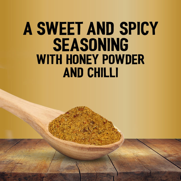 A wooden spoon holds a mound of Jr Hot Honey Seas X6 over a rustic wooden table against a gold background with text describing it as a sweet and spicy seasoning with honey powder and chilli.