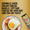 A bottle of Schwartz Jr Every Bagel Seas X6 is shown next to a plate of avocado and egg on toast with bacon to illustrate serving suggestions.