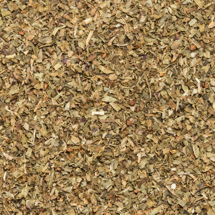 A detailed close up view of dried and chopped leaves of Schwartz Basil 10G showing a mix of green and brown herbal textures.