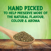 A wooden spoon filled with dried herbs rests on a rustic table to highlight that Schwartz Basil 10G is hand picked to help preserve more of the natural flavour colour and aroma.