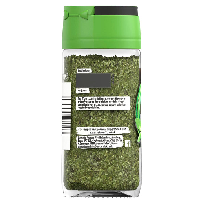 A clear glass jar of Schwartz Marjoram, 8G shows the dried green herbs inside and a label with cooking tips for creamy sauces and roasted vegetables.