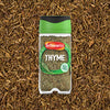 A jar of Schwartz Thyme 11 G is positioned in the center of a bed of loose, dried thyme.