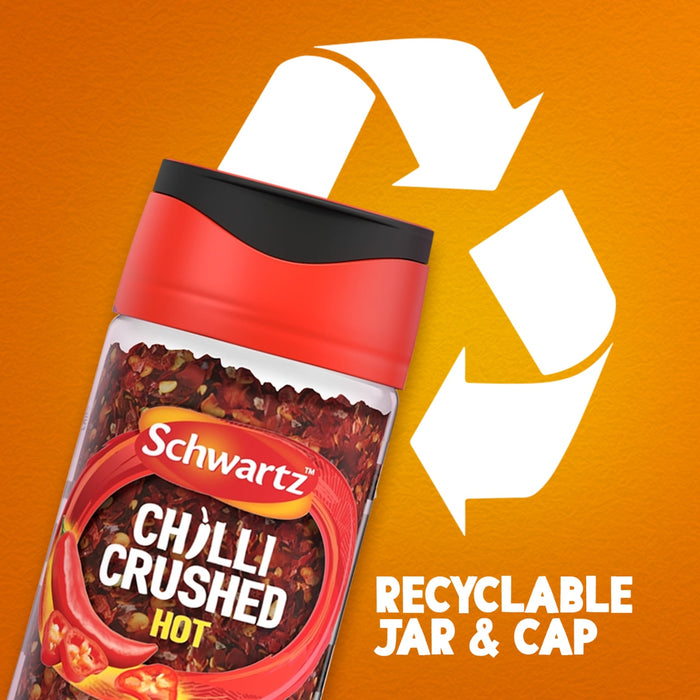 A jar of Schwartz Crushed Chillies 29G is shown against an orange background with a large recycling symbol to emphasize that the jar and cap are recyclable.