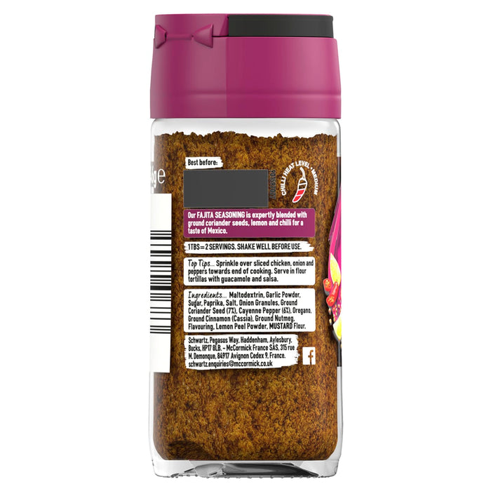 A clear glass jar of Schwartz Fajita Seasoning 46G is shown from the back, displaying the label with ingredients, usage tips, and company information.