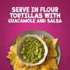 A serving suggestion for Schwartz Fajita Seasoning 46G featuring a bowl of fresh guacamole surrounded by crunchy tortilla chips against a vibrant pink background with text instructions to serve in flour tortillas with guacamole and salsa.