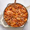 A large skillet filled with rigatoni pasta, mushrooms, and a hearty meat sauce is perfectly seasoned with Schwartz Spicy Italian Seasoning, 42G and topped with shredded cheese.