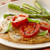 A delicious meal of grilled chicken topped with melted cheese, tomatoes, and basil, served with asparagus, shows a serving suggestion for Schwartz Garlic Salt, 73G.