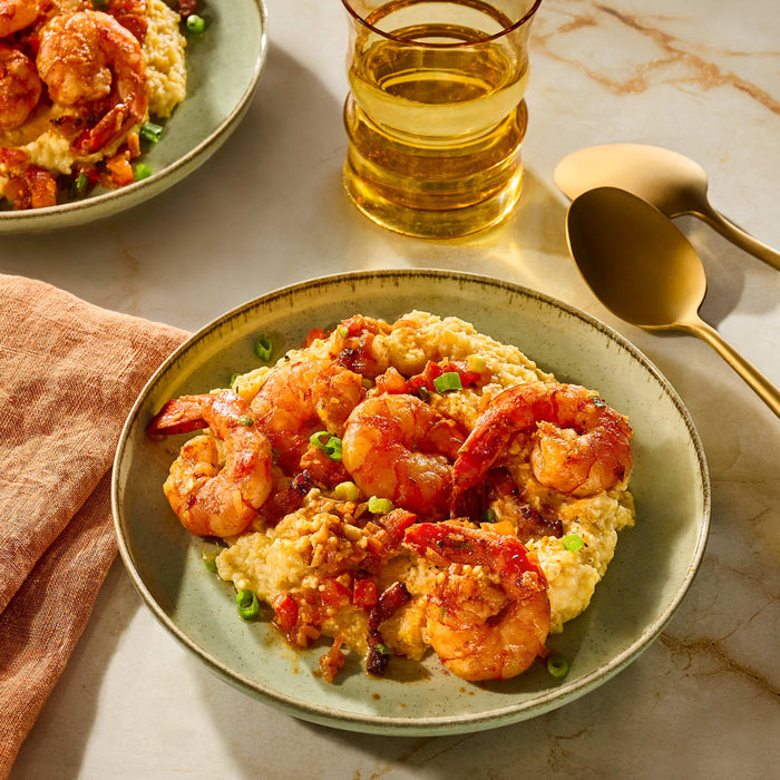 A plate of savory shrimp and grits is seasoned with Schwartz Paprika Hot, 34G to add a bold and spicy kick to the dish.