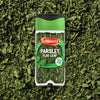 A clear jar of Schwartz Parsley, 3G is shown against a background of the dried green herb.