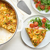 A delicious vegetable frittata, seasoned with Schwartz Parsley, 3G, is served on a plate with a side salad.