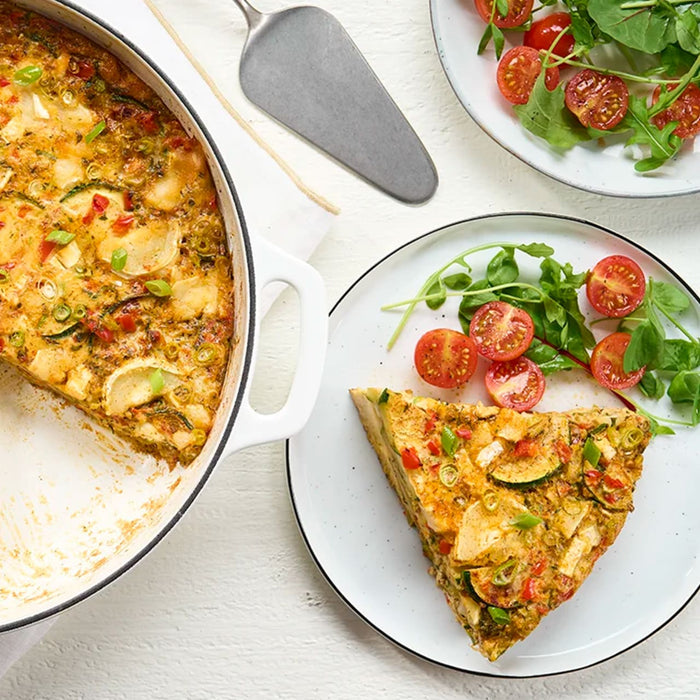 A delicious vegetable frittata, seasoned with Schwartz Parsley, 3G, is served on a plate with a side salad.