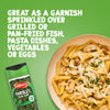 A jar of Schwartz Parsley, 3G is shown next to a bowl of creamy mushroom pasta, demonstrating its use as a garnish.