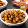 A white bowl filled with roasted chickpeas is seasoned and served as a snack, with a jar of Schwartz Garam Masala, 30G visible in the background.