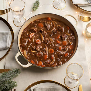A hearty beef stew, made with a rich seasoning blend from the Barrel collection, is served in a large pot on a festively decorated dinner table.