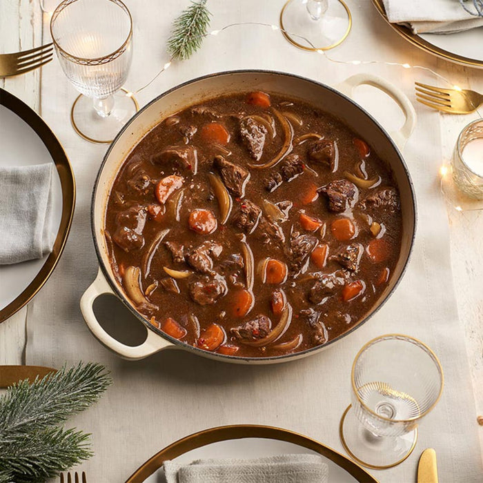 A hearty beef stew, made with a rich seasoning blend from the Barrel collection, is served in a large pot on a festively decorated dinner table.