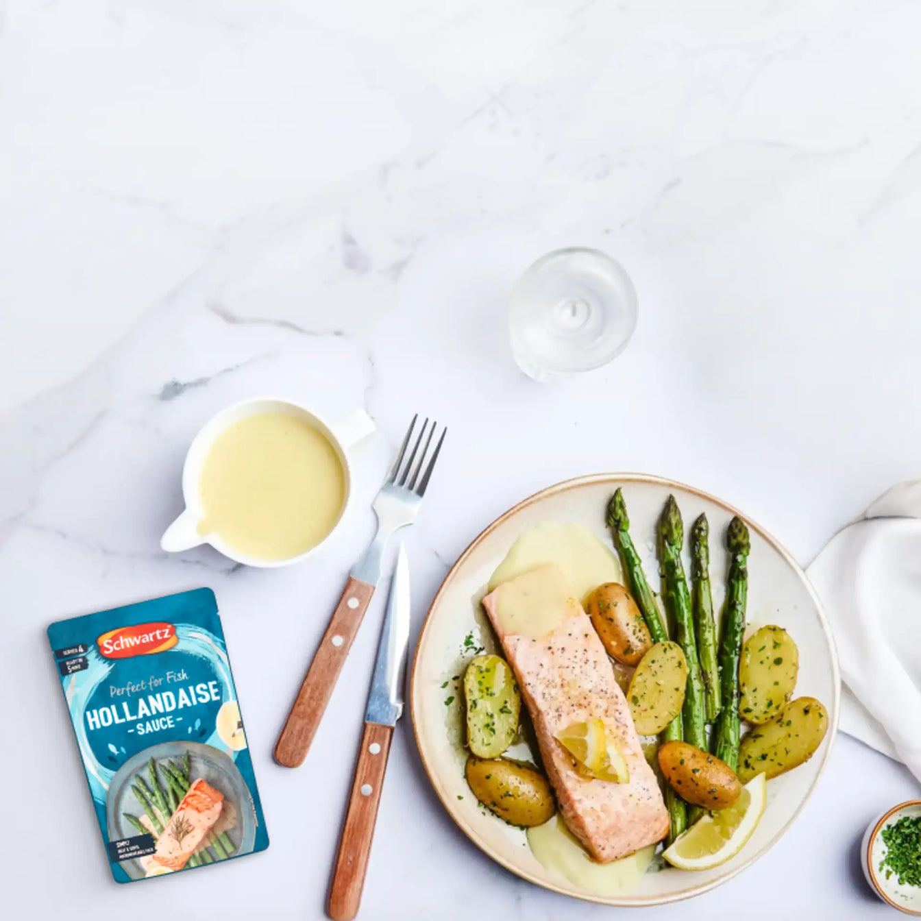 Schwartz Hollandaise Sauce packet beside a plate of salmon, potatoes, and asparagus