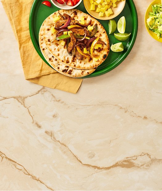 Tortillas with toppings on a green plate on a marble surface