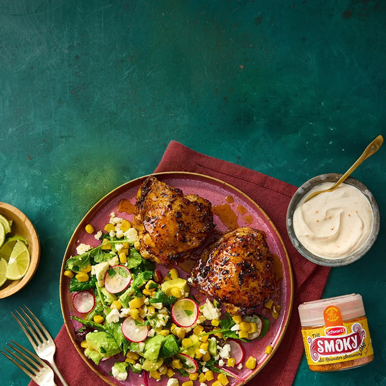Plated dish of grilled chicken with a salad on a red napkin, featuring a jar of Smokey All Rounder Seasoning.