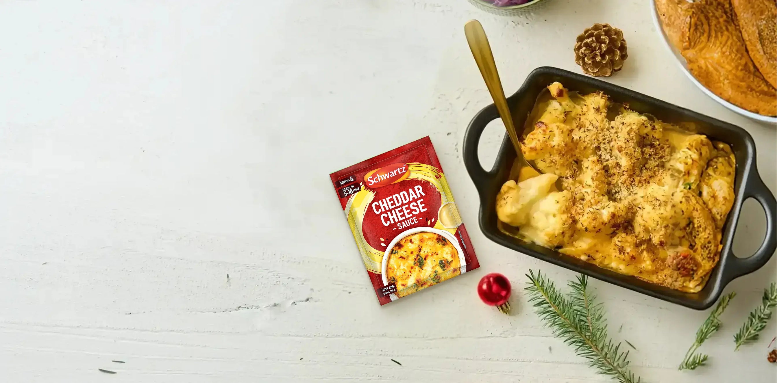 Baked dish with a golden brown topping in a black baking dish on a light gray surface.