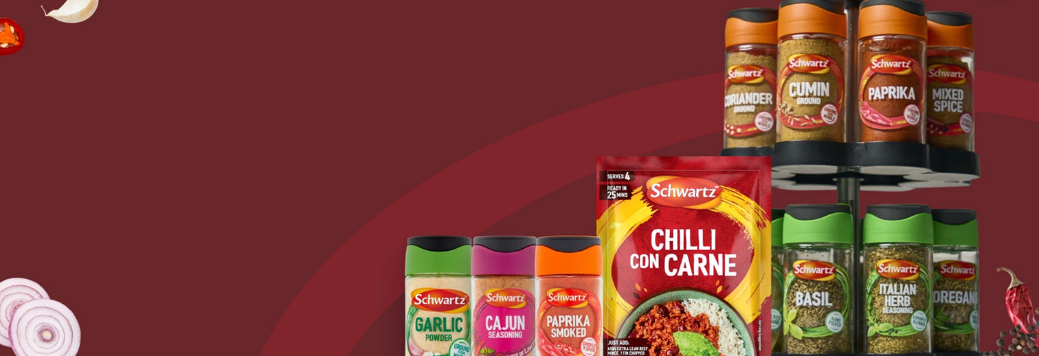 A promotional display of Schwrta spices and seasonings, including Chili con Carne, Garlic, Cajun, Paprika, Basil, and Cinnamon, arranged on a black tiered shelf against a solid dark red background.