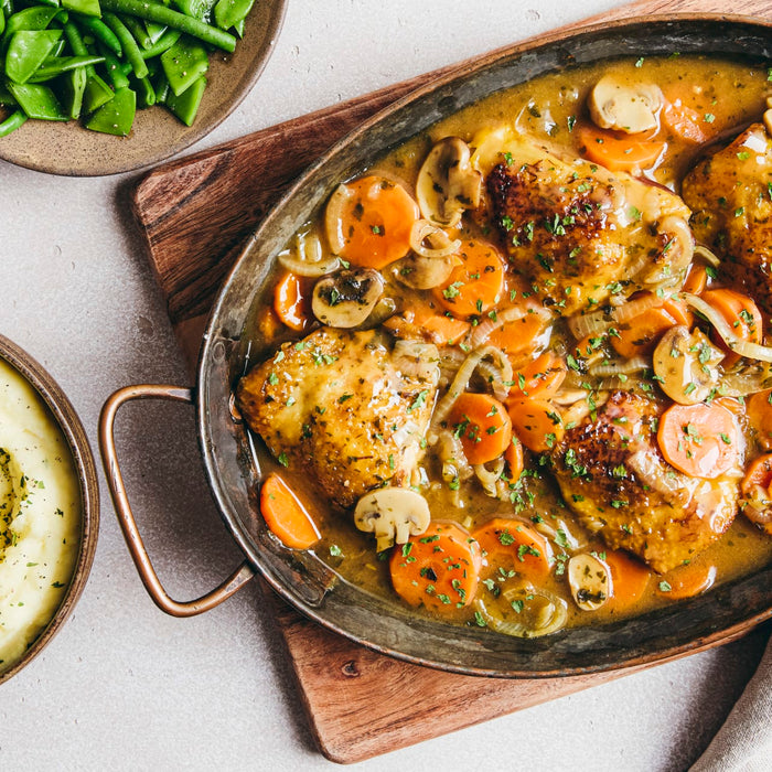 A hearty meal featuring golden chicken thighs and sliced vegetables prepared with Schwartz Chicken Casserole Recipe Mix 36G served alongside mashed potatoes and green beans.