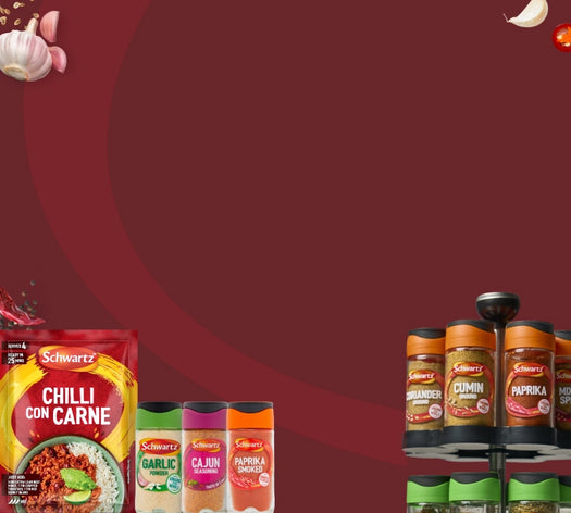 A promotional display of Schwrta spices and seasonings, including Chili con Carne, Garlic, Cajun, Paprika, Basil, and Cinnamon, arranged on a black tiered shelf against a solid dark red background.