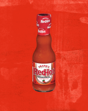 Bottle of Frank's RedHot hot sauce on a red background